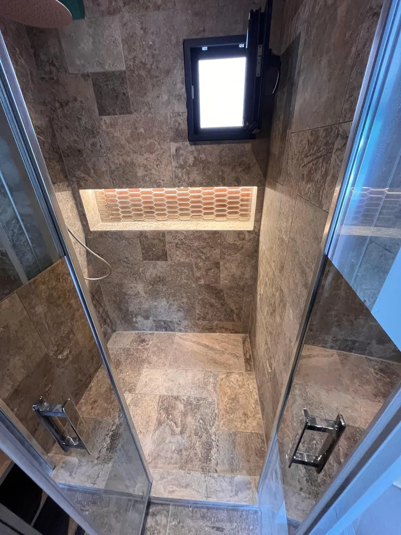 La m&ecirc;me douche vue du dessus&nbsp;: sol et murs en dalles effet pierre, niche lumineuse sur toute la largeur, chantier SFG B&acirc;ti Concept