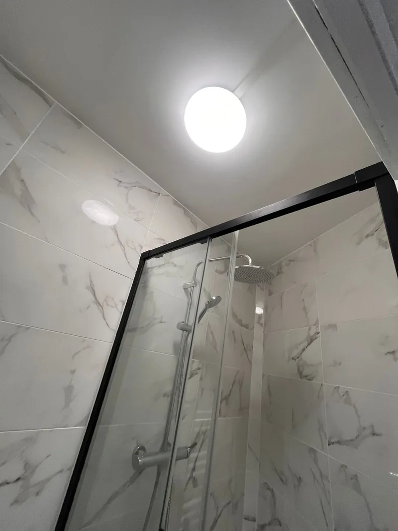 La m&ecirc;me douche termin&eacute;e, fa&iuml;ence effet marbre, cabine d&rsquo;angle et pomme de t&ecirc;te
