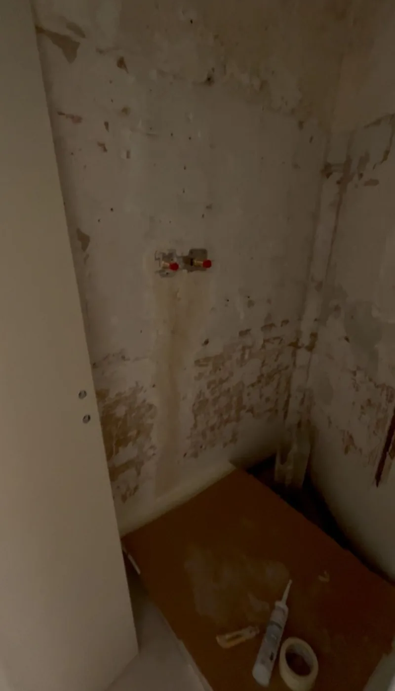 Emplacement de la douche avant travaux, murs mis &agrave; nu et sol bois apparent