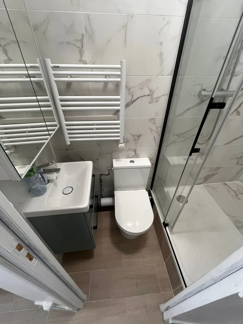 Salle de bain livr&eacute;e&nbsp;: meuble vasque, WC, s&egrave;che-serviettes et sol en carrelage imitation bois, chantier SFG B&acirc;ti Concept