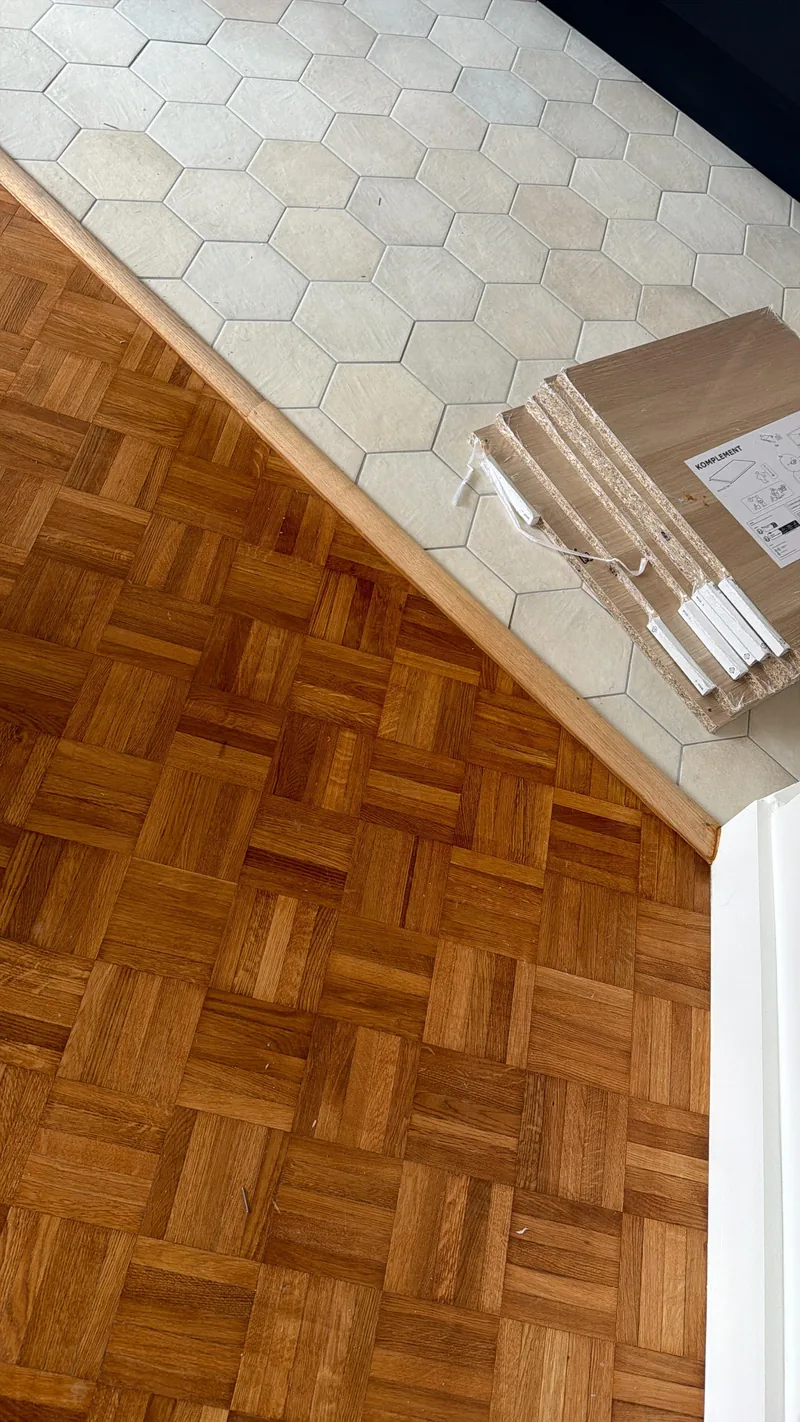 Jonction entre le parquet mosa&iuml;que du s&eacute;jour et le carrelage hexagonal de la cuisine, chantier SFG B&acirc;ti Concept