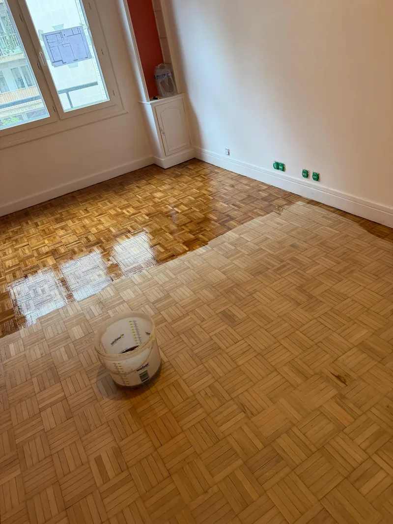 Parquet mosa&iuml;que&nbsp;: &agrave; gauche le passage de vitrificateur frais, &agrave; droite le bois encore mat, chantier SFG B&acirc;ti Concept