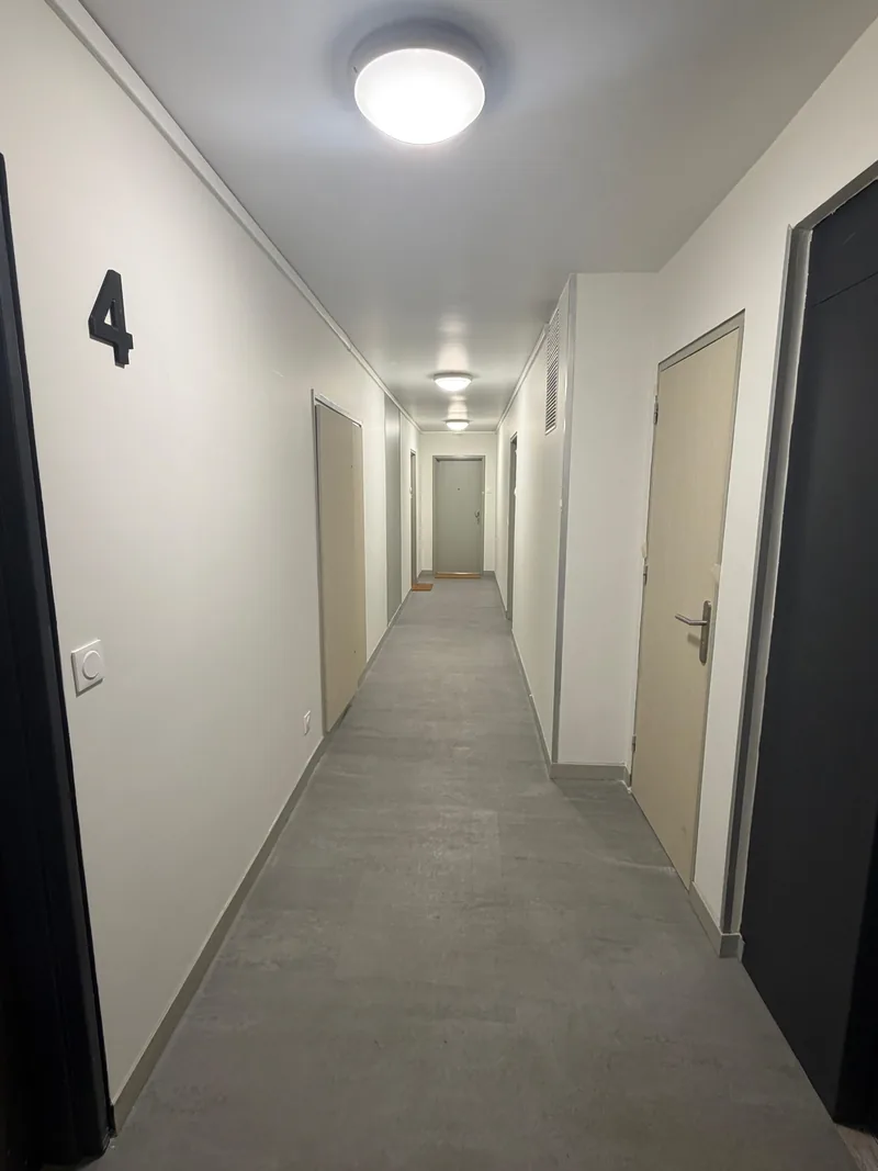 Couloir du 4<sup>e</sup> &eacute;tage, &eacute;clairage en place et sol souple pos&eacute;, chantier SFG B&acirc;ti Concept